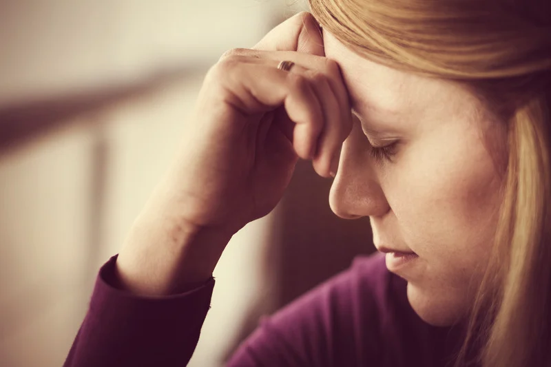 Mujer con gesto de preocupación, representando el peso emocional que soporta.