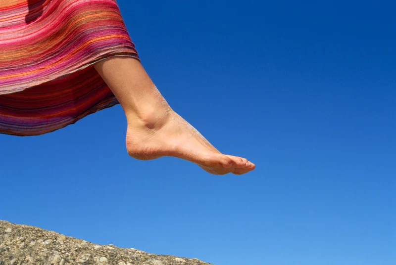 Pie avanzando con cuidado al borde de una superficie, simbolizando dar un paso.