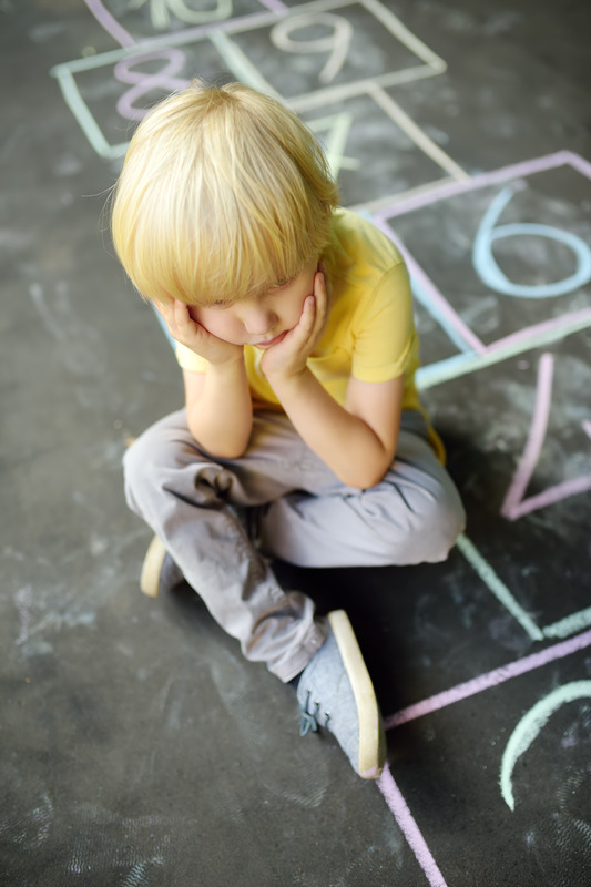 Niño solo en un espacio social representando el aislamiento y la falta de interacción.