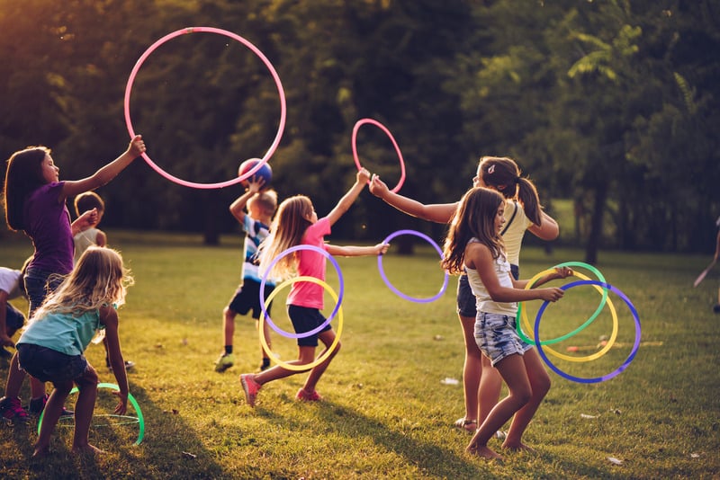 Niños jugando juntos al aire libre con aros, representando la interacción social
