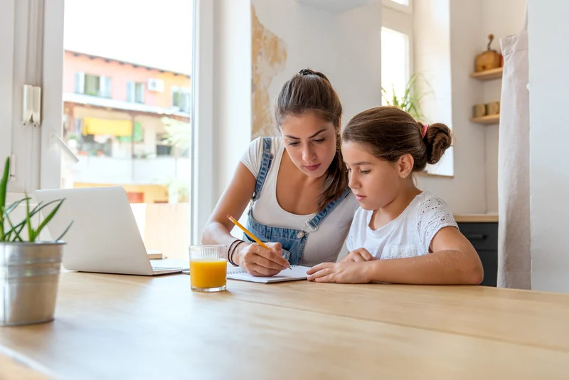 Madre e hija repasando contenidos escolares de forma tranquila durante las vacaciones.