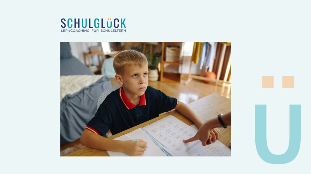 Niño haciendo deberes con expresión seria mientras un adulto señala la hoja de ejercicios.