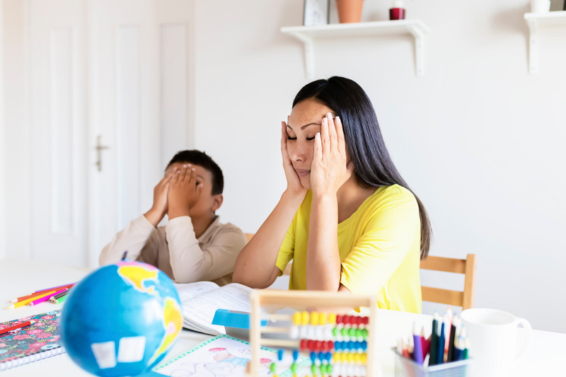 Madre e hijo estresados haciendo los deberes en casa