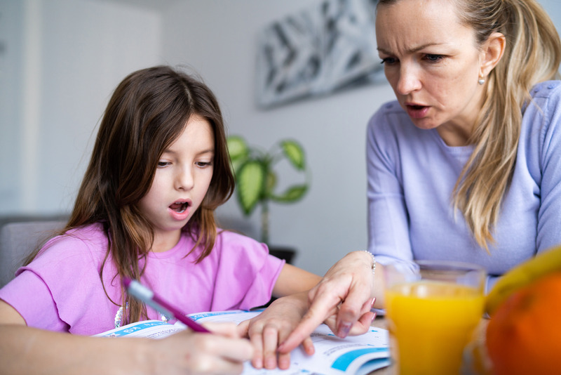 Madre perdiendo la paciencia mientras ayuda a su hija con los deberes, ejemplo de cómo se pierden los nervios con los deberes cuando las emociones parentales se desbordan.