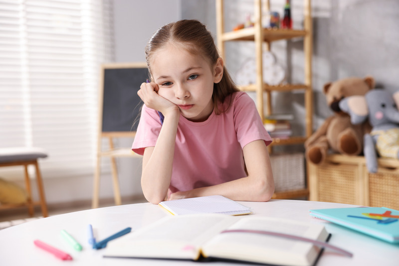 Niña bloqueada frente a los deberes escolares en casa